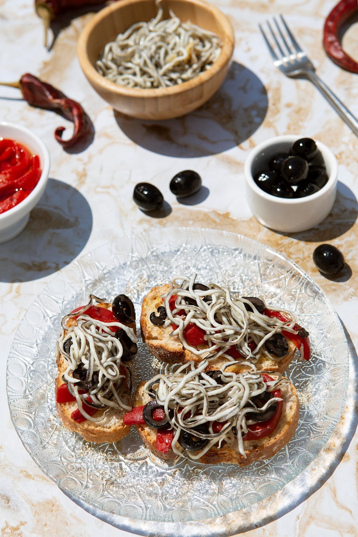 Tostadas de gulas con pimientos y aceitunas